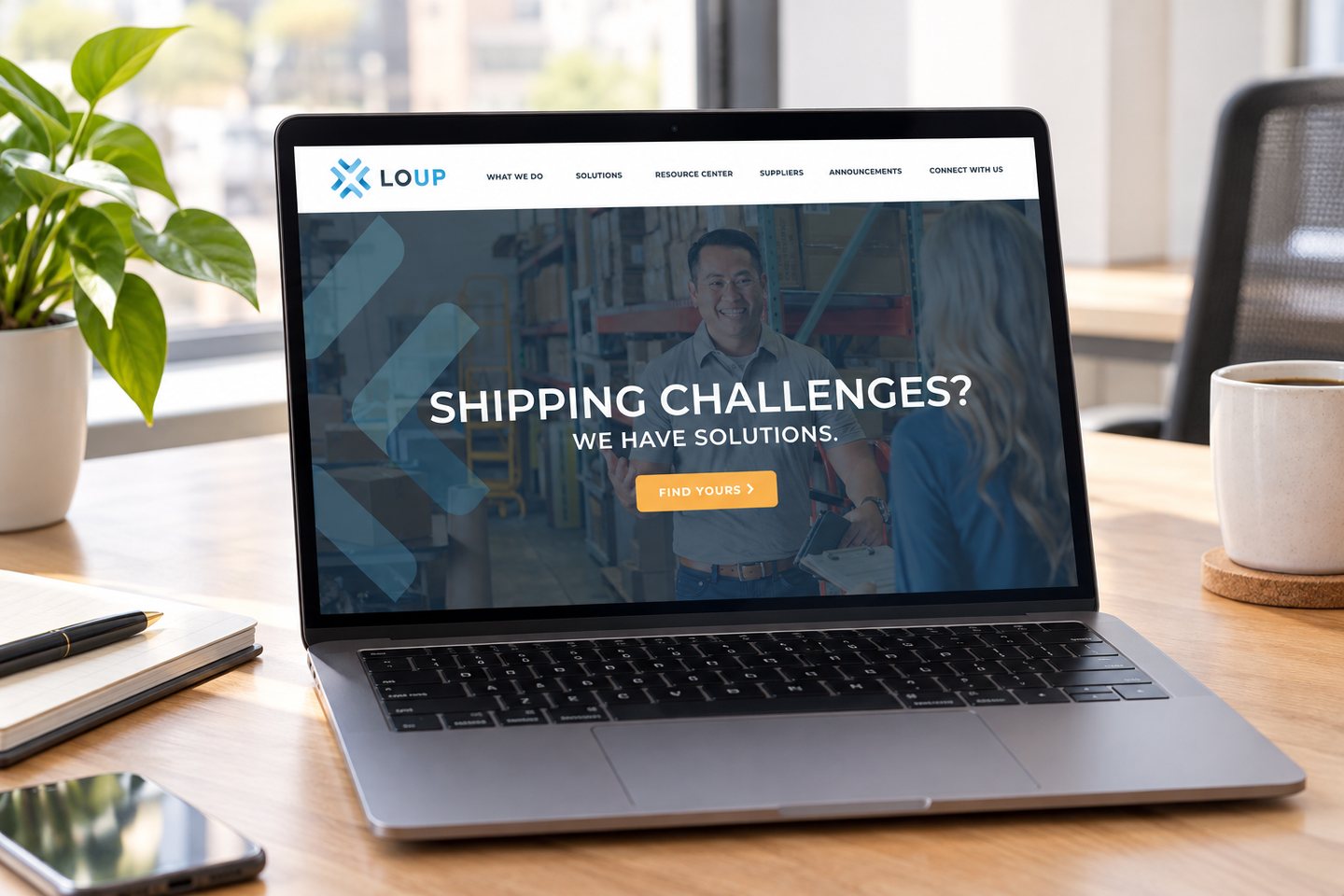 A laptop on a desk showing the Loup Logistics homepage, headlined Shipping challenges? We have solutions, with a Find yours button.